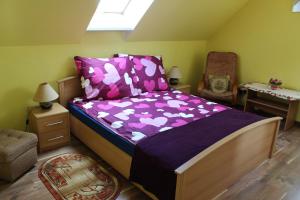 sypialnia z łóżkiem z fioletową pościelą i krzesłem w obiekcie Apartment Helena w Bielsku Białej