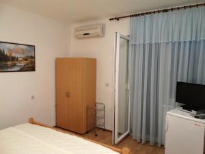 a bedroom with a bed and a cabinet and a television at Pansion Belveder in Crikvenica