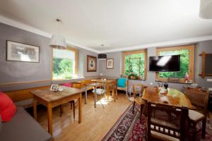 a living room with tables and chairs and a tv at Villa Blumegg in Hermagor