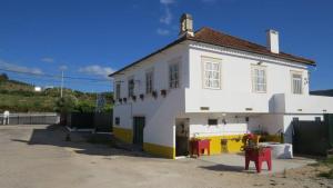 a white building with a yellow and white at Vivenda Maria de Lourdes in Maiorga