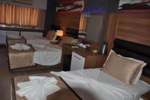 a hotel room with two beds and a mirror at Hotel Kabacam in İzmir