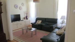 a living room with a couch and a tv at Vivenda Maria de Lourdes in Maiorga