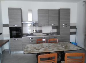 盧加尼亞諾的住宿－Affittacamere Di Paola，厨房配有桌椅和炉灶。