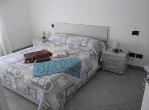 una camera da letto con un letto con copriletto grigio e bianco. di Affittacamere Di Paola a Lugagnano