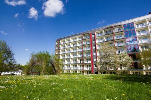 a large building with a grassy field in front of it at Aparthotel am Rennsteig in Wurzbach