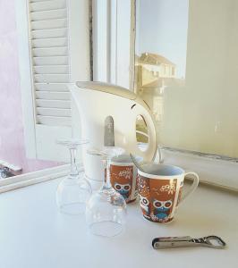 a group of cups and glasses sitting on a window sill at Iliotropio Art in Chania Town
