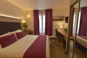 A bed or beds in a room at Hôtel Renoir Montparnasse