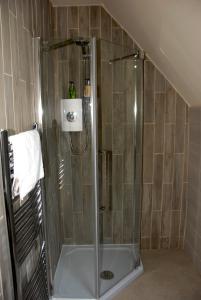 a shower with a glass door in a bathroom at Cleavers Lyng 16th Century Country House in Herstmonceux