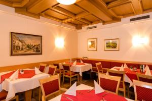 a restaurant with tables and chairs with red napkins at Gasthof Grillitsch Rösslwirt in Obdach