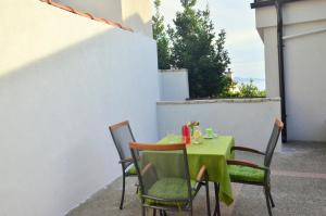 a green table and chairs sitting on a patio at Villa Biondina in Senj