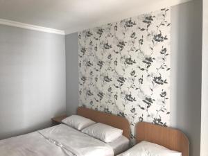 卡瓦里亞提的住宿－Kvariati - Guest House，一间卧室设有一面墙,墙上装饰着花卉图案的壁纸
