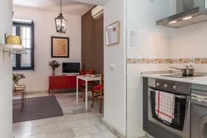 una cucina con piano cottura forno superiore accanto a un tavolo di Apartamentos Mariscal a Siviglia