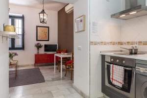 a kitchen with a stove top oven next to a table at Apartamentos Mariscal in Seville