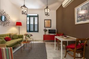 sala de estar con sofá y mesa en Apartamentos Mariscal, en Sevilla