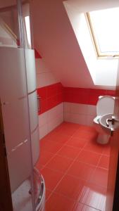 czerwona łazienka z toaletą i oknem w obiekcie Penzion Vanůvecký Dvůr w Telczu