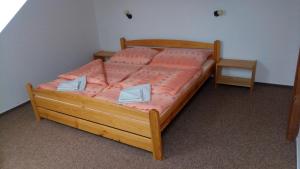 een slaapkamer met een houten bed met oranje lakens bij Penzion Vanůvecký Dvůr in Telč