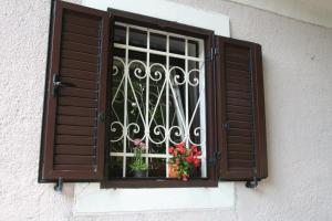 a window with some flowers in a window at House Rukavina in Bakarac