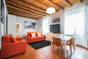 ein Wohnzimmer mit orangefarbenen Möbeln und einem Tisch in der Unterkunft Sole&Luna Comolake Apartments in Como