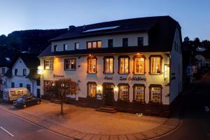 a building with a car parked in front of it at Hotel Restaurant zum Schlossberg in Wadern