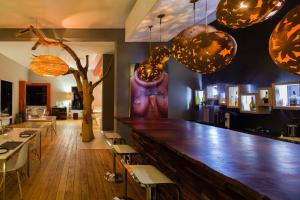 um bar com um balcão de madeira, cadeiras e luzes em The Olive Exclusive All-Suite Hotel em Windhoek