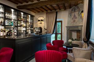 bar w restauracji z czerwonymi krzesłami i ladą w obiekcie Villa Le Calvane w mieście Montespertoli