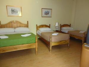 Zimmer mit 3 Betten und einem TV. in der Unterkunft Pristine Hotel in Rawang