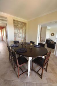 a dining room with a table with chairs and a painting at Villa Crisaflor in Moncarapacho