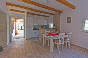 cocina y comedor con mesa y sillas en Nella, en Zadar