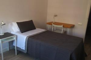 a small bedroom with a bed and a desk at A3A Baixa Mar in Torredembarra