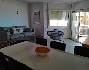 a living room with a table and a couch at A3A Baixa Mar in Torredembarra