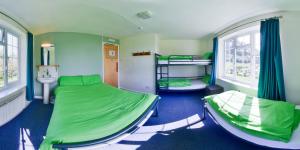 a room with two bunk beds and a sink at YHA Land's End - Cot Valley in St. Just