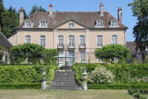 une grande maison avec un escalier en face de celle-ci dans l'établissement Chateau de Villette, à Poil