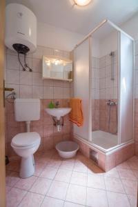 a bathroom with a toilet and a shower and a sink at Apartments Mate in Komiža