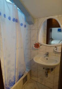 a bathroom with a sink and a shower curtain at Pansion Belveder in Crikvenica +18 photos