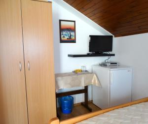 a bedroom with a desk and a tv on a wall at Pansion Belveder in Crikvenica