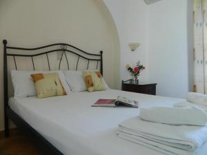 una camera da letto con un letto bianco e asciugamani di Ioanna Apartments ad Agios Prokopios