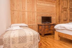 a bedroom with a bed and a tv in a room at Appartamenti & Wellness Piero Gros in Sauze dʼOulx
