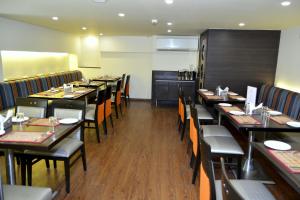 a dining room with tables and chairs in a restaurant at Hotel Orion Premiere in Panaji
