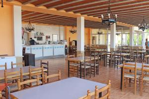 un restaurante con mesas y sillas y una cocina en Camping y Bungalows Monmar en Moncófar