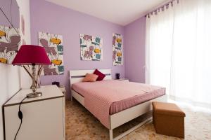 a bedroom with purple walls and a bed with a lamp at Casa Vacanze Circe in Sperlonga