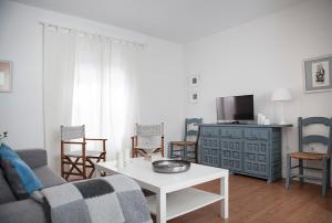 sala de estar con sofá, mesa y sillas en Apartamento Mendoza, en Sevilla