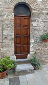 a wooden door on a stone building with stairs at Casa Venturi in Gubbio