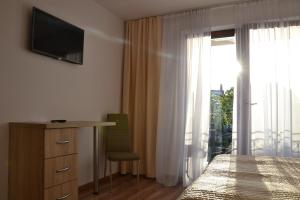 ヤスタルニャにあるWil-Art Jastarnia Pokoje i apartamentyのベッドルーム1室(ベッド1台、デスク、窓付)