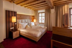 因斯布鲁克Hotel Goldener Adler, BW Signature Collection的卧室里有一张床和一台电视机