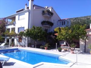 a villa with a swimming pool in front of a building at Villa Roza in Trogir