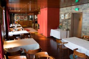 a restaurant with tables and chairs and a red wall at Hotel Laatokan Portti in Parikkala