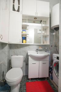 La salle de bains est pourvue de toilettes blanches et d'un lavabo. dans l'établissement Apartment Mira, à Budva