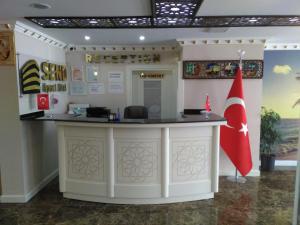 a reception counter in a building with a red flag at Send Apart Otel in Antalya