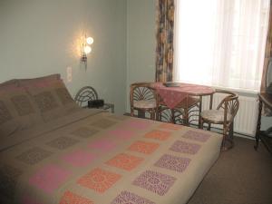 1 dormitorio con 1 cama, mesa y sillas en B&B Het Wit Beertje, en Brujas