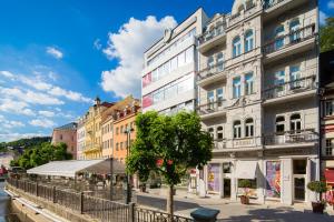 a building on a street next to a river at Rubin Luxury Apartments in Karlovy Vary